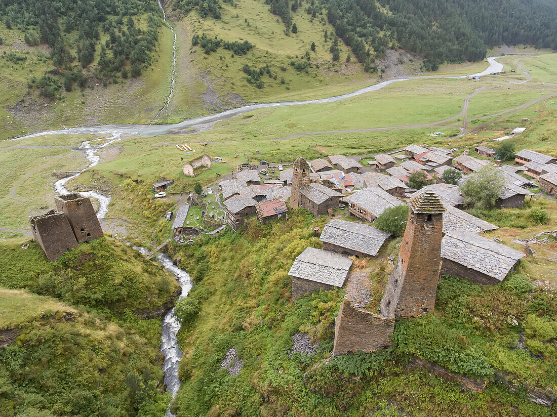 Aerial view of the mountainside village of Dartlo with a stream running next to its ruins of medieval towers in Tusheti National Park; Dartlo, Kakheti, Georgia