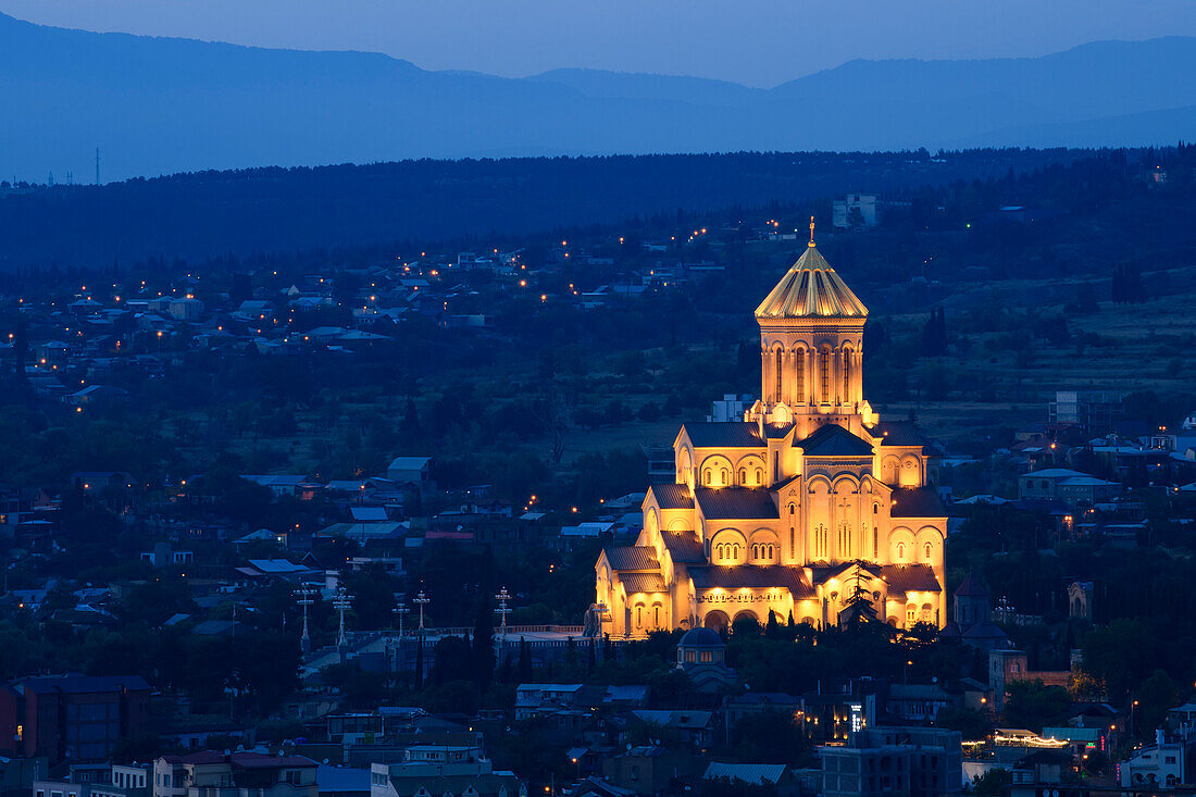 Die Kathedrale der Heiligen Dreifaltigkeit von Tiflis (Sameba), eine traditionelle Kirche aus dem 21. Jahrhundert auf dem Elia-Hügel im historischen Viertel Avlabari, beleuchtet bei Nacht; Tiflis, Georgien.