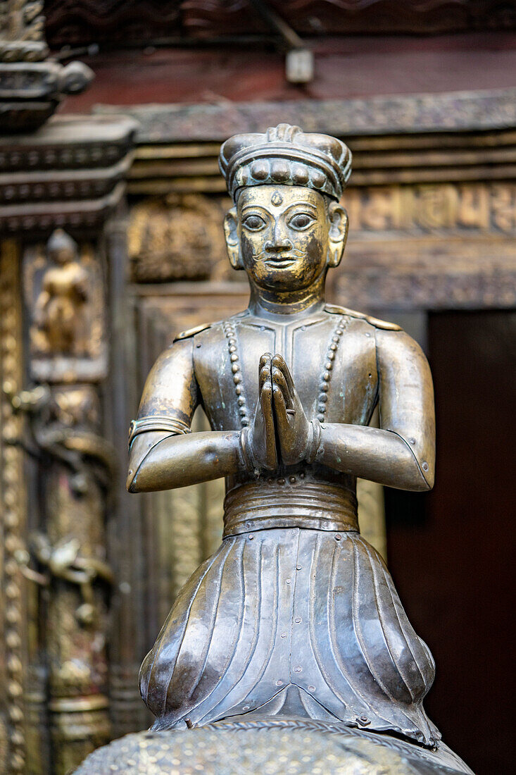 Close-up of a brass statue of a praying figure in Kwa Bahal Golden Temple in the old city of Patan or Lalitpur built in the twelfth century by King Bhaskar Varman in the Kathmandu Valley; Patan (Lalitpur), Kathmandu Valley, Nepal