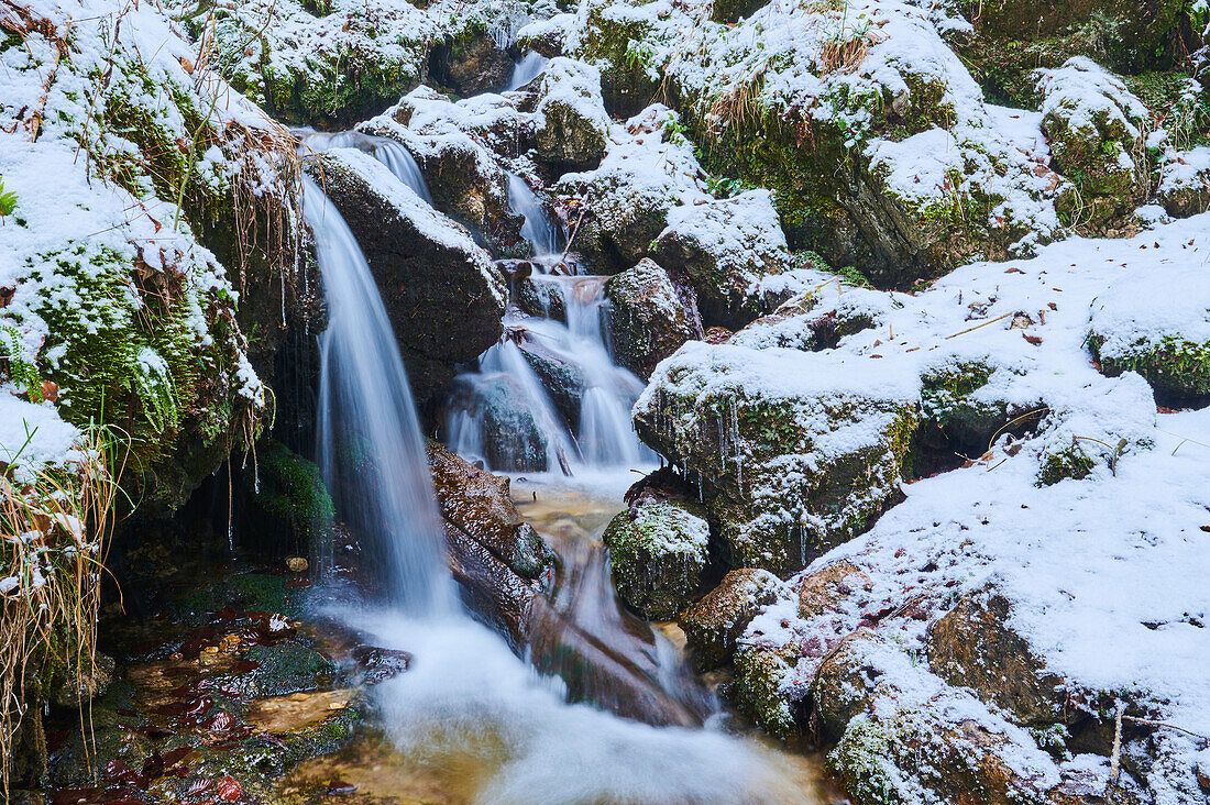 Nahaufnahme eines kleinen, verschneiten Wasserfalls in der Janosikove Diery im Winter; Kleine Fatra, Karpaten, Terchova, Slowakei.