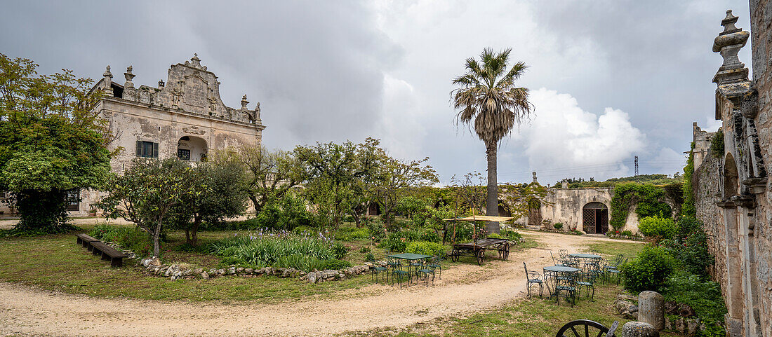 Graue Wolken über einer italienischen Villa und dem dazugehörigen Garten in den Hügeln über Ostuni; Ostuni, Apulien, Italien.