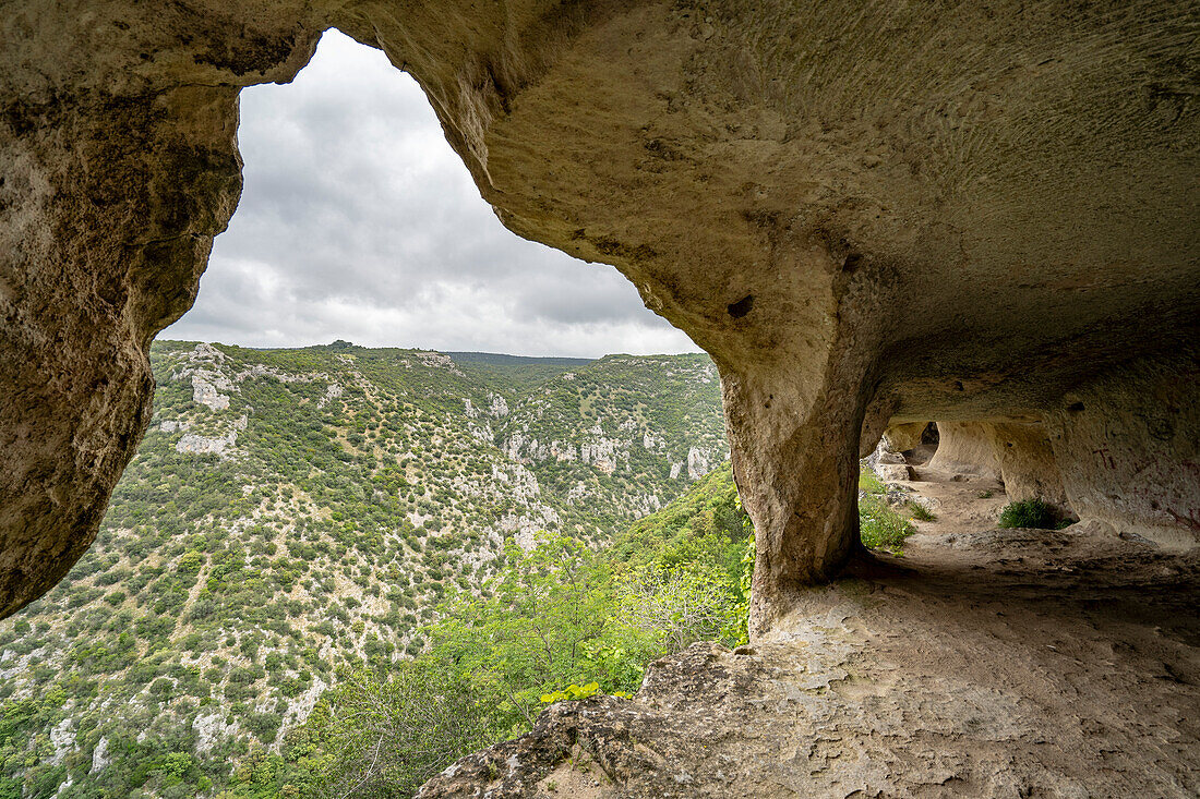 Blick von einer Felsenhöhle entlang der Wanderwege durch den Fluss Gravina di Matera und den Park bei Matera; Matera, Basilikata, Italien.