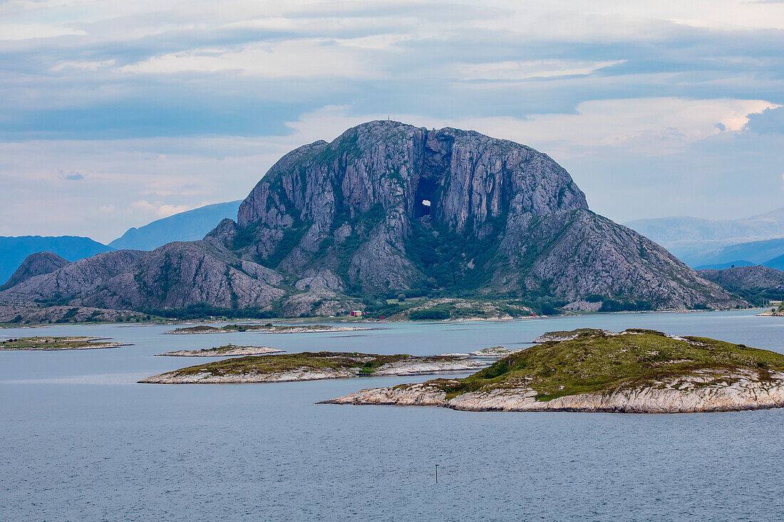 Die Granitkuppel von Torghatten, bekannt für ihr Loch in der Mitte, auf der Insel Torget in der Gemeinde Bronnoy; Landkreis Nordland, Region Helgeland, Norwegen.
