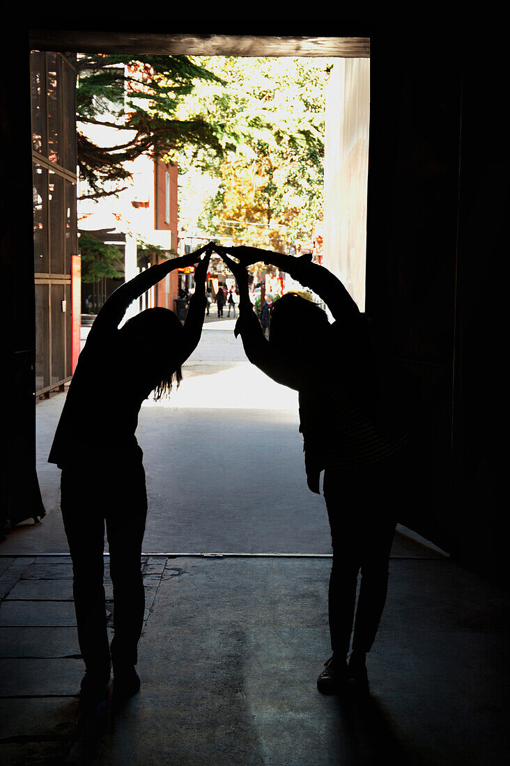 Two People Forming A Bridge With Their Hands; Beijing, China