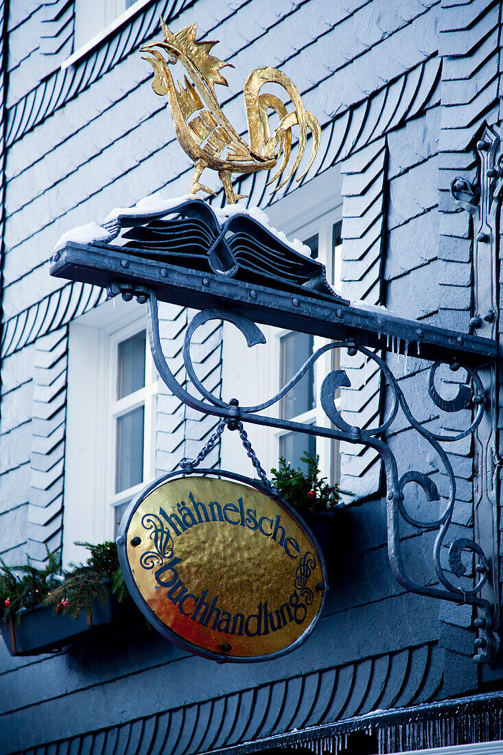 Ein Schild mit einem goldenen Hahn hängt an einem Gebäude; Hachenburg Rheinland-Pfalz Deutschland