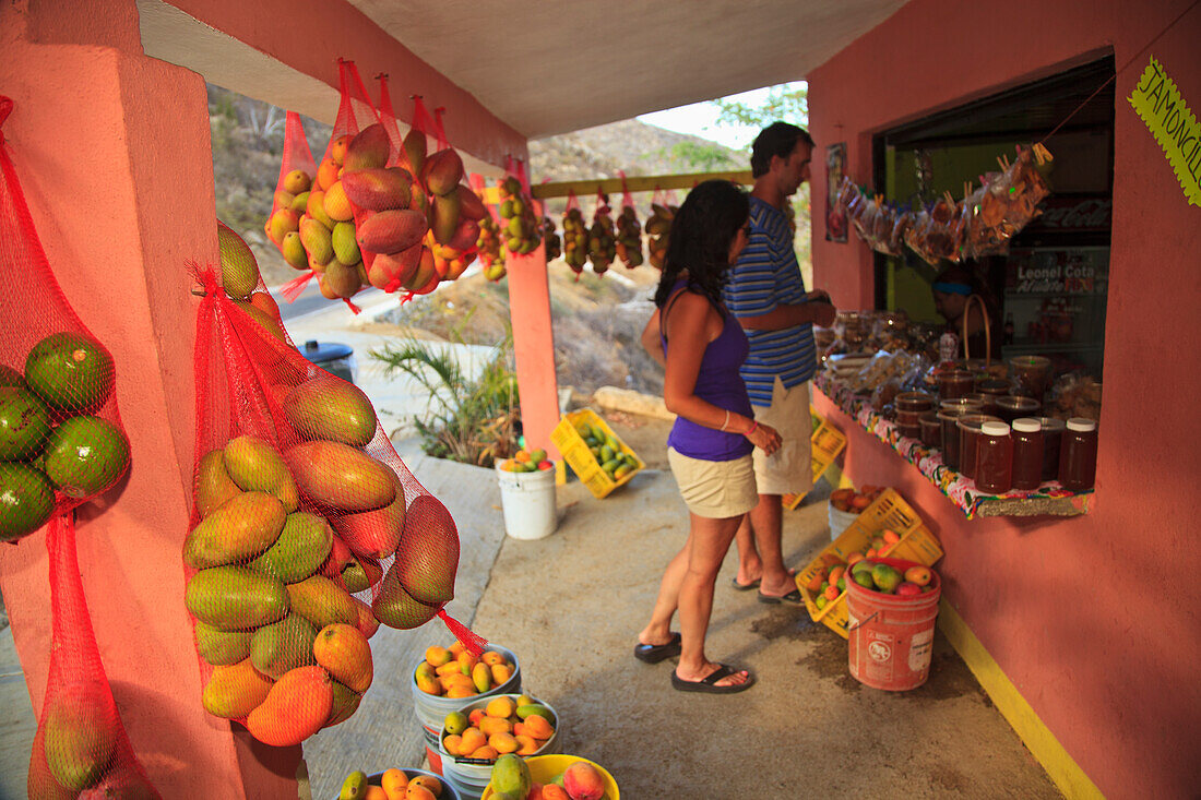 A Couple Looks At A Roadside Fruit Stand Near Los Cabos Area; San Jose Del Cabo Baja California Sur Mexico