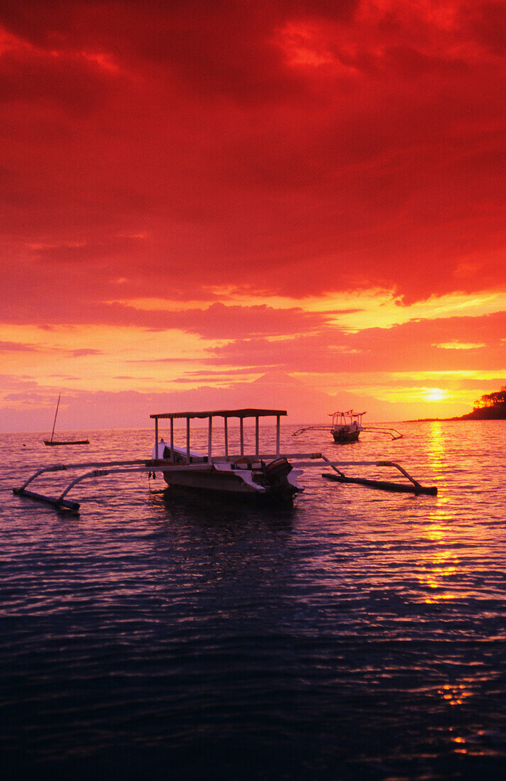 Indonesien, Lombok, Boote auf dem Meer bei Sonnenuntergang; Sengigi.