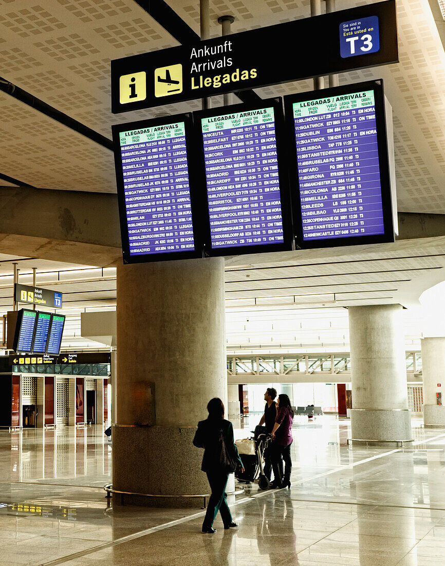 People Looking At Arrival Information Boards In The Airport; Malaga, Malaga Province, Spain