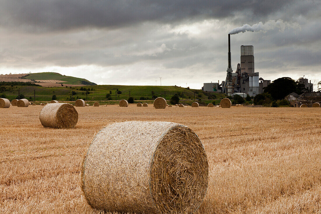 A Cement Production Plant With Hay Bales In A Field In The Foreground; Lothian Scotland