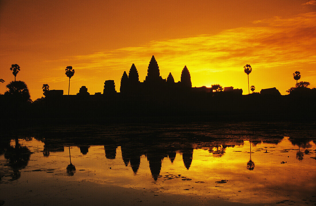 Cambodia, Siem Reap, Silhouette of temple against orange sky during sunrise; Angkor wat