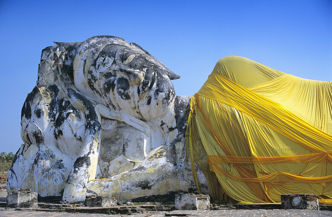 Liegende Budda-Statue mit gelbem Tuch umwickelt