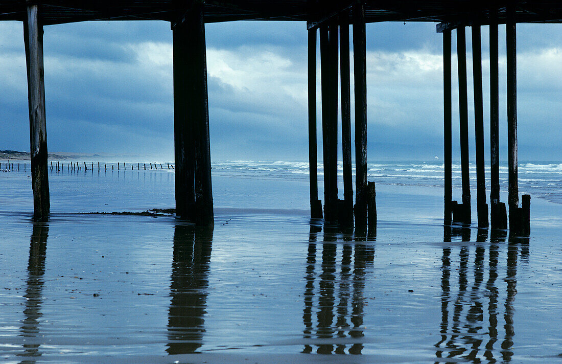 USA, Kalifornien, Reflexionen auf dem nassen Ufer, umrahmt von der Silhouette des Piers; Pismo Beach.