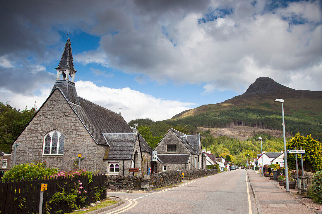 A Road Lined With Houses And A Church Building Going Through A Village; Glencoe Scotland