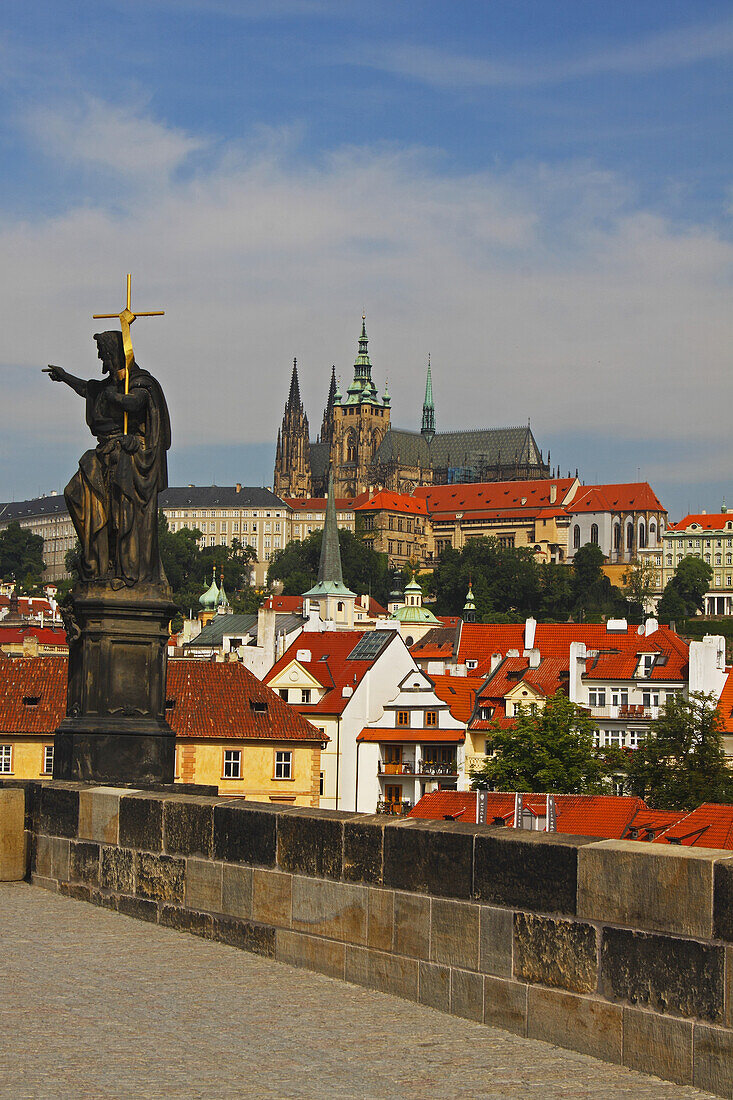 Statue On Charles Bridge With Royal Palace In The Background; Prague Czech Republic