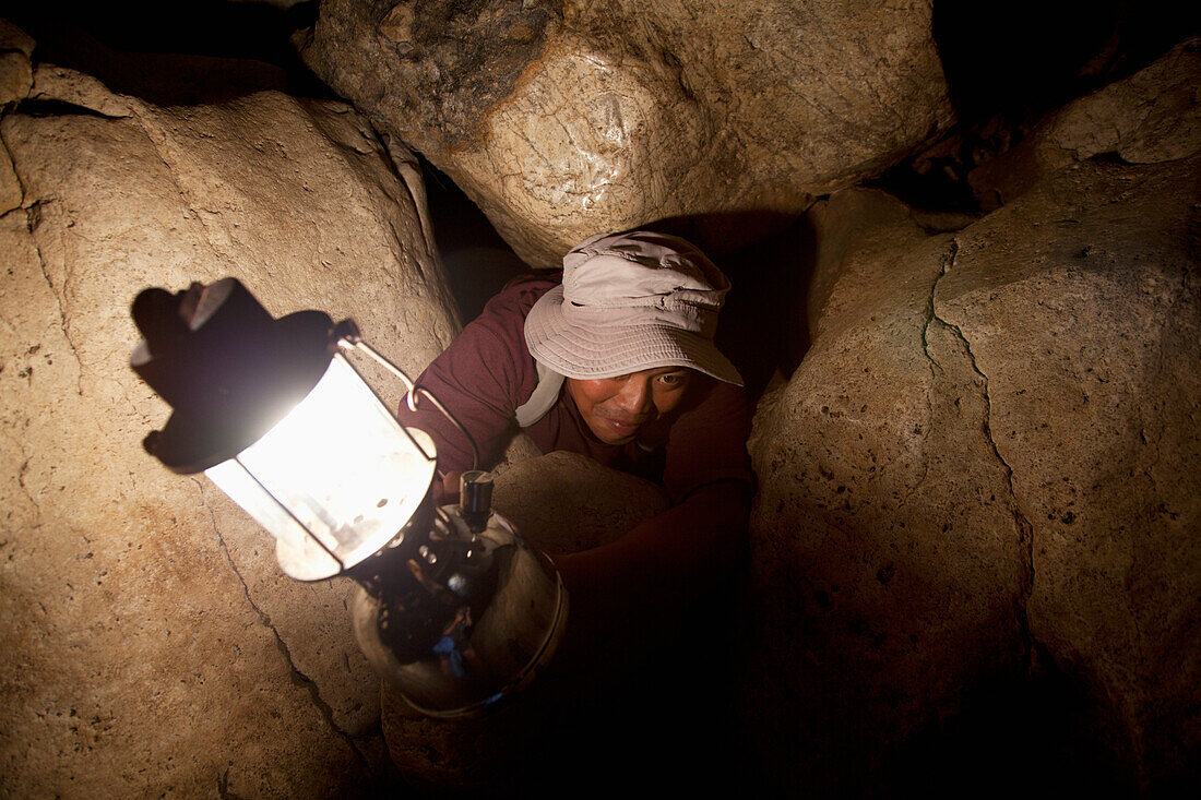 Ein philippinischer Reiseleiter hält eine Laterne in der Sumaging-Höhle oder großen Höhle in der Nähe von Sagada; Luzon Philippinen