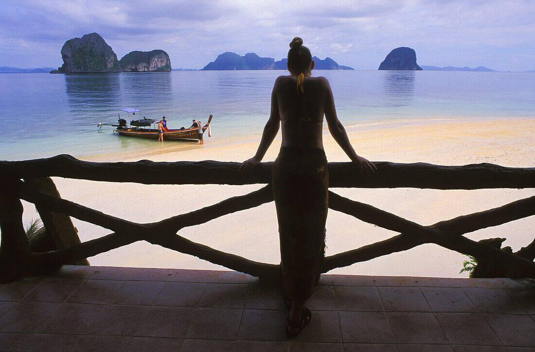 Eine Touristin in einem Sarong-Rock blickt über den Strand der tropischen Insel Koh Ngai oder Ko Ngai in der Nähe von Trang; Koh Ngai Thailand.