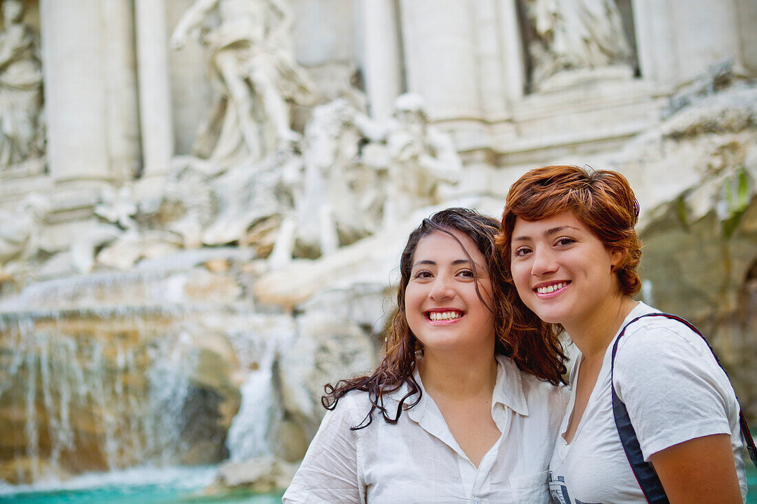 Zwei Freunde posieren vor dem Trevi-Brunnen; Rom Italien