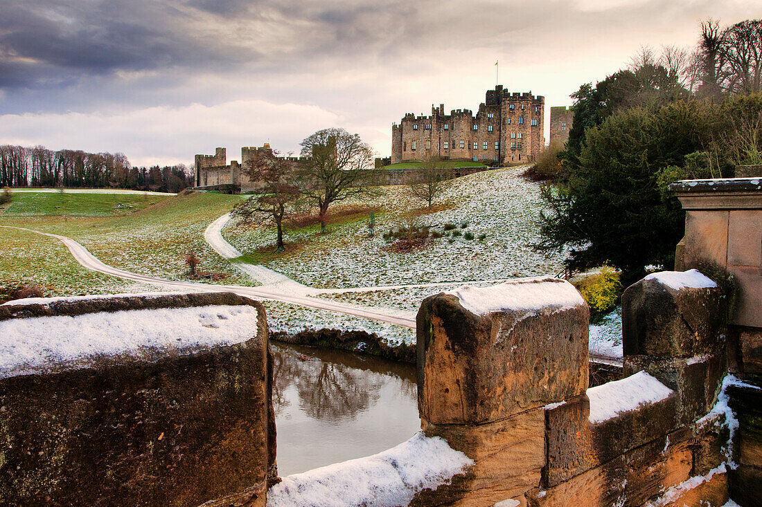 Snow On The Hills And Bridge With Alnwick Castle In The Background; Alnwick Northumberland England