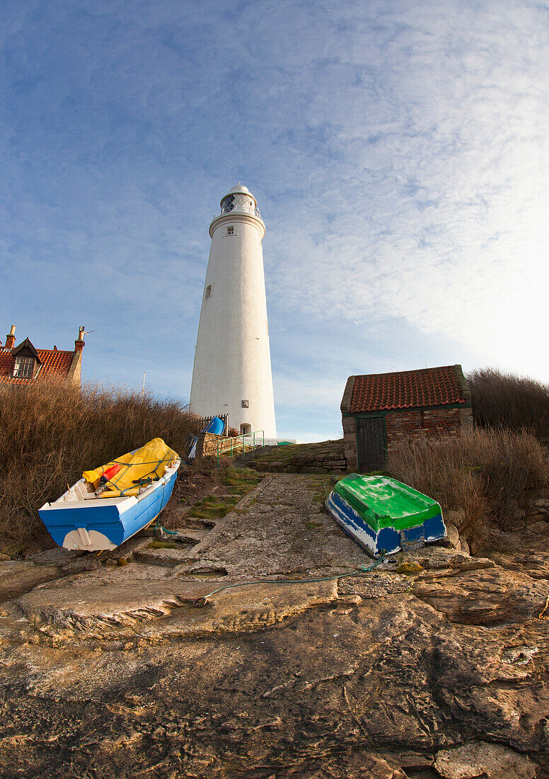 Rowboats Abandoned On The Shore In Front Of The Lighthouse On St. Mary's Island; Northumberland England