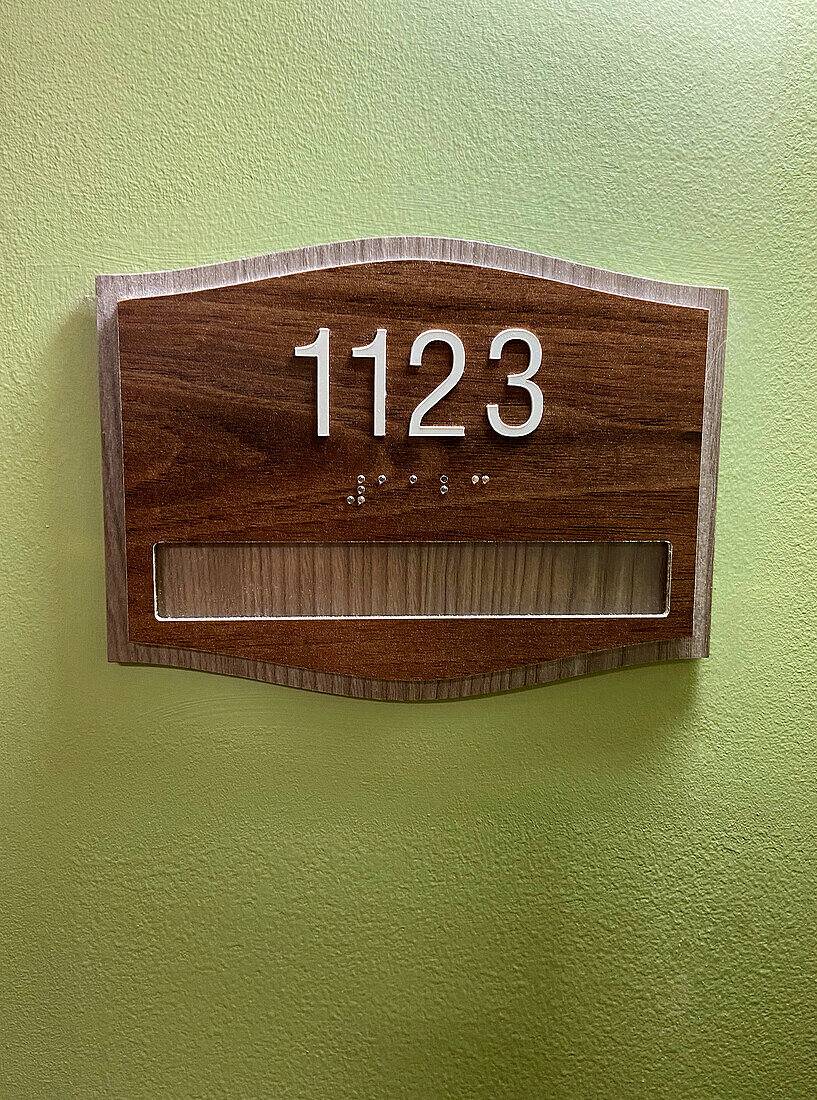 1123 auf Wohnungstür-Schild mit Braille-Zahlen