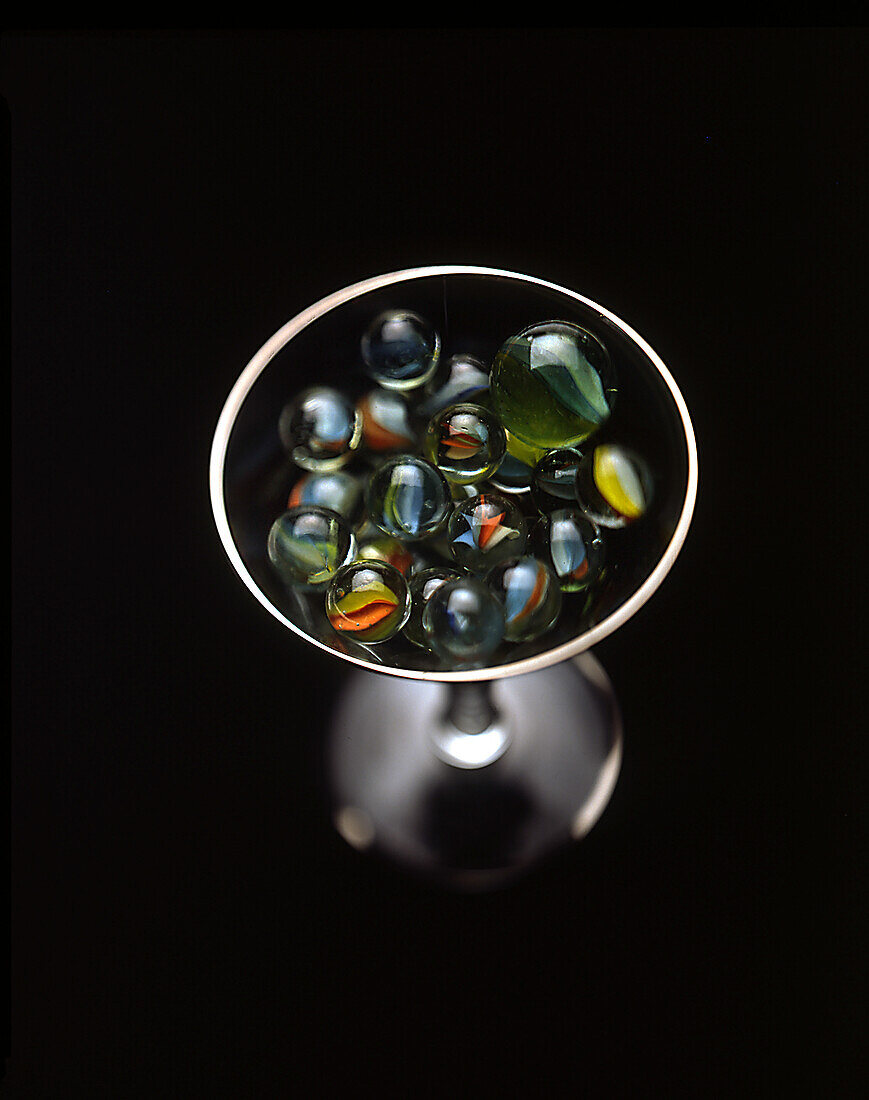 Blick aus hohem Winkel auf ein mit Murmeln gefülltes Cocktailglas