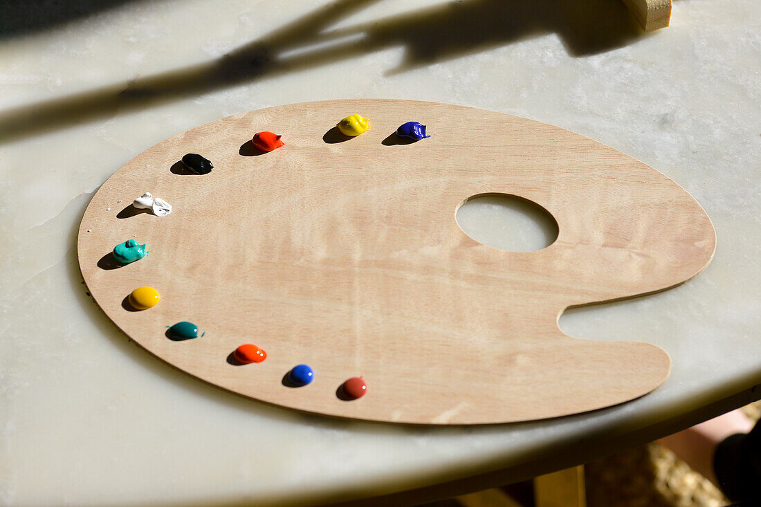 Holzmalpalette eines Kindes mit Farbklecksen