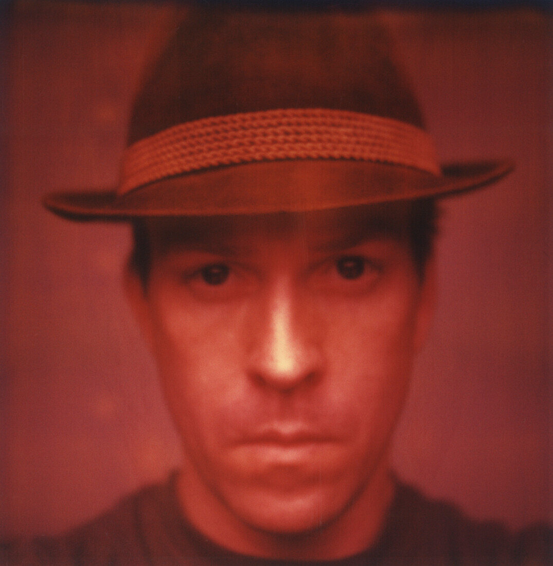 Head and Shoulders Portrait of Mid-Adult Man in Hat with Serious Expression