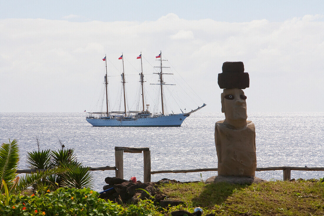 Moai und die Viermast-Barkentine Esmeralda im Hafen von Hanga Roa, Rapa Nui (Osterinsel), Chile