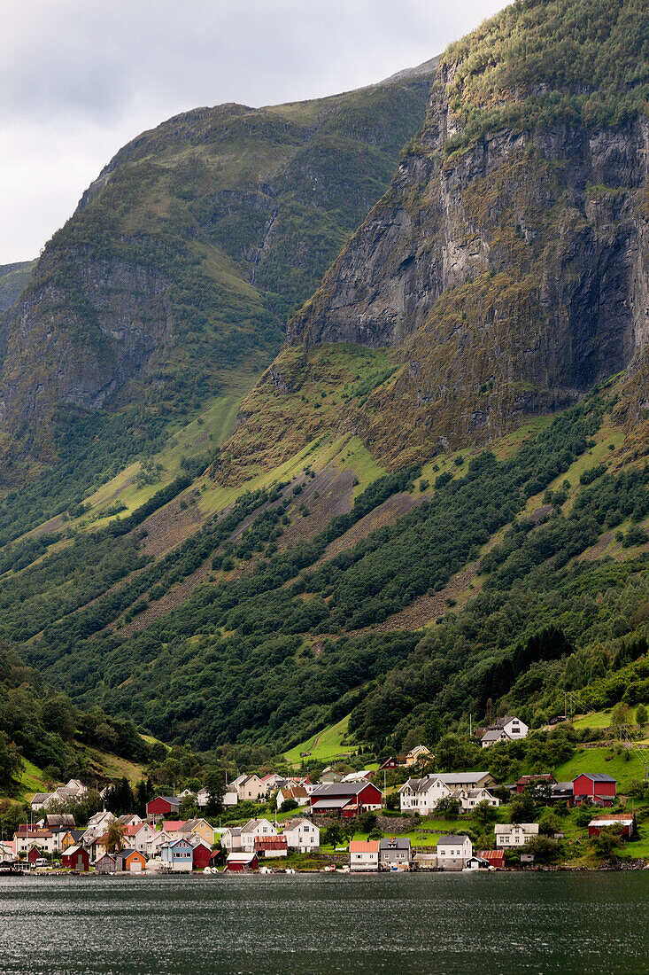 Steiler Berghang mit Häusern im Tal entlang des Wassers; Undredal Sognefjord Norwegen