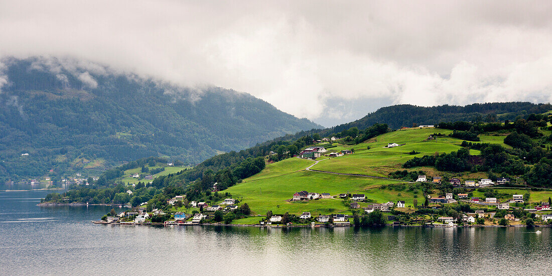 Häuser auf einem Hügel am Ufer des Hardangerfjords; Hardangervidda Norwegen