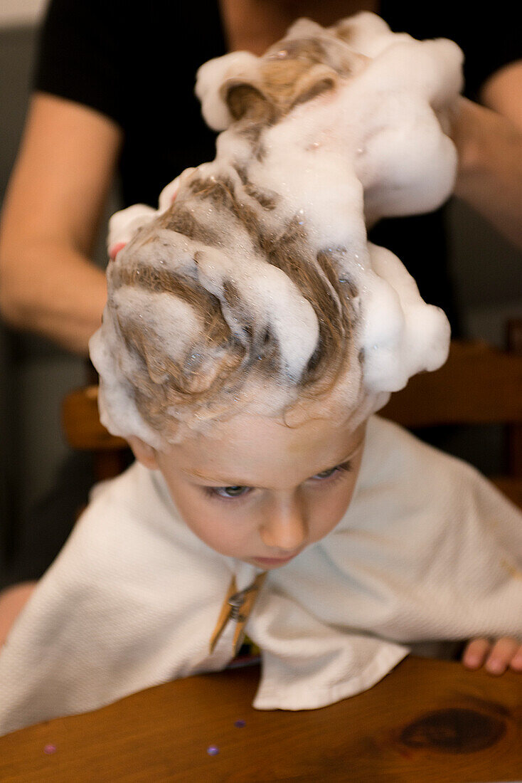 Junger Junge lässt sich die Haare waschen