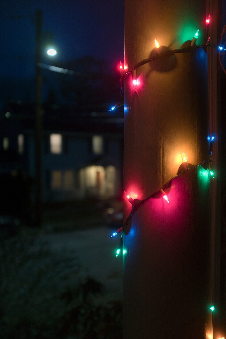 Weihnachtsbeleuchtung um die Säule der Veranda bei Nacht