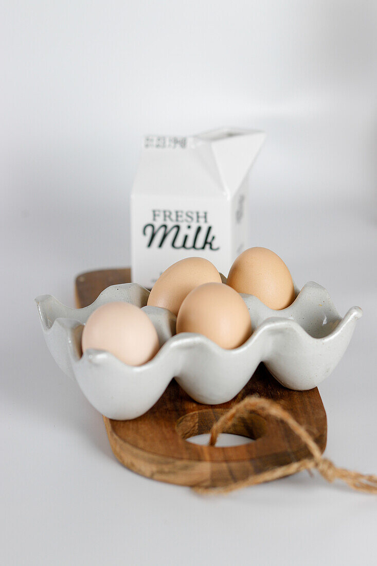 Eggs in ceramic egg holder and milk