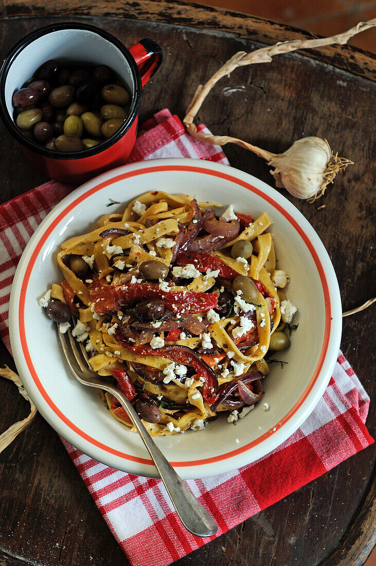 Hausgemachte Tagliatelle mit Paprika, Knoblauch, Oliven und Feta