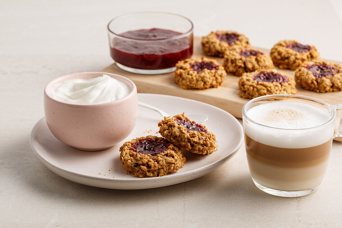 Jam oat cookies served with yogurt and latte macchiato