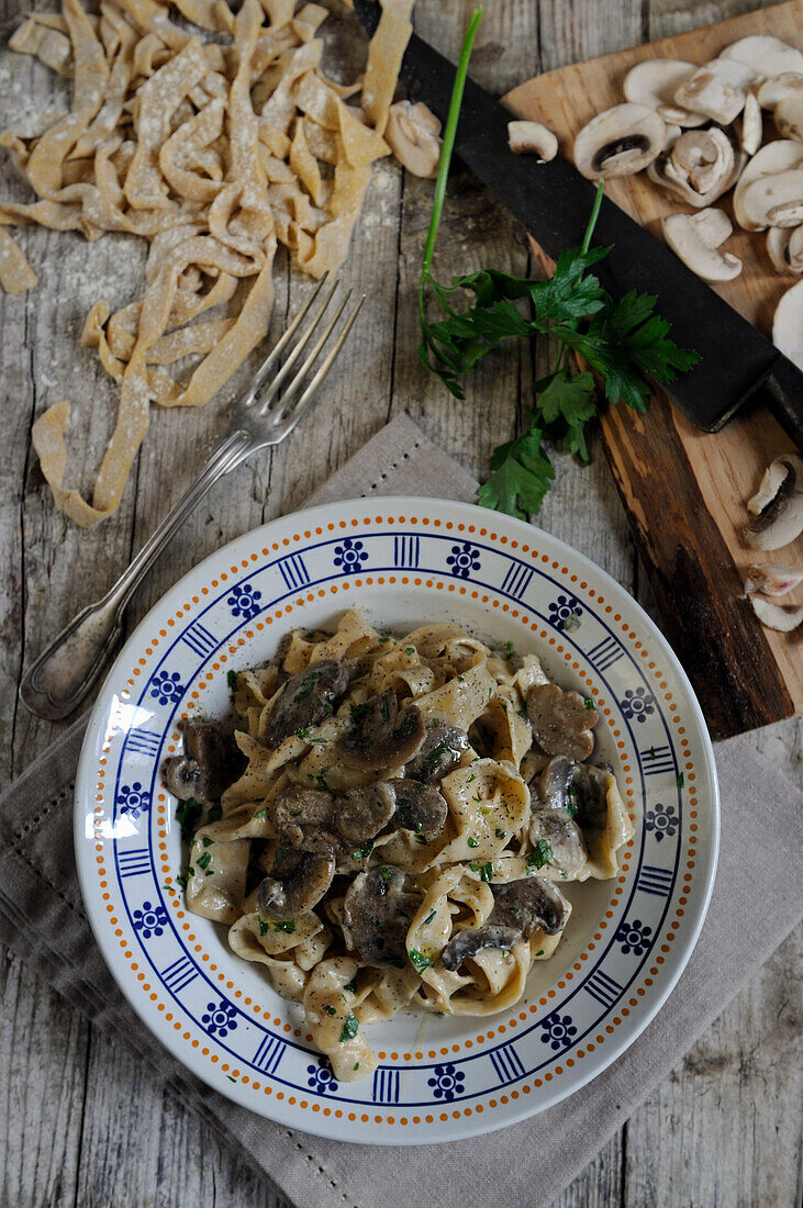 Von Hand geschnittene Tagliatelle aus frischen Eiern mit cremiger Pilzsauce