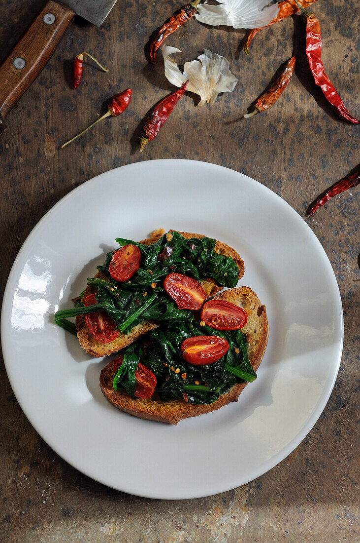 Bruschetta with spinach, oven-roasted tomatoes and chilies