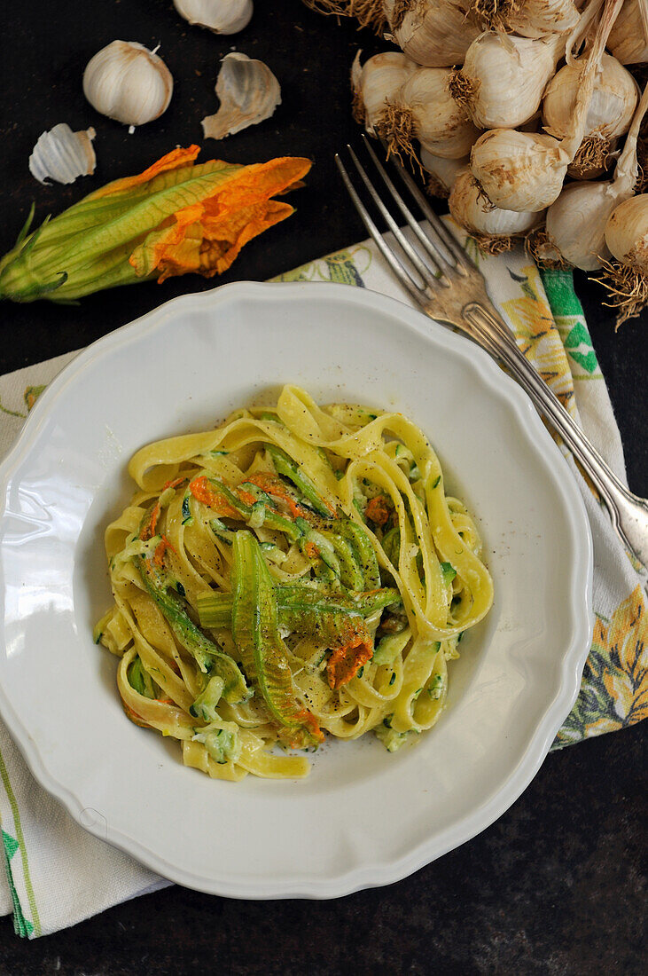 Hausgemachte Tagliatelle mit Kürbisblüten und Knoblauch