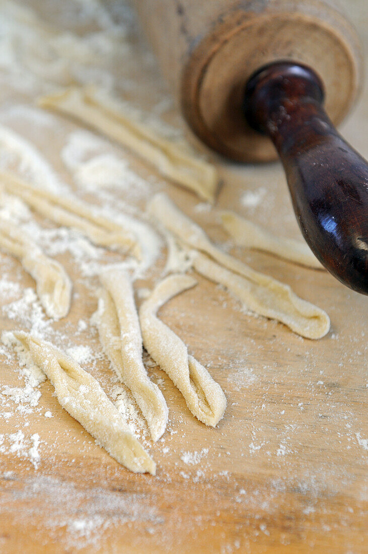 Close-up of homemade casarecce pasta with rolling pin