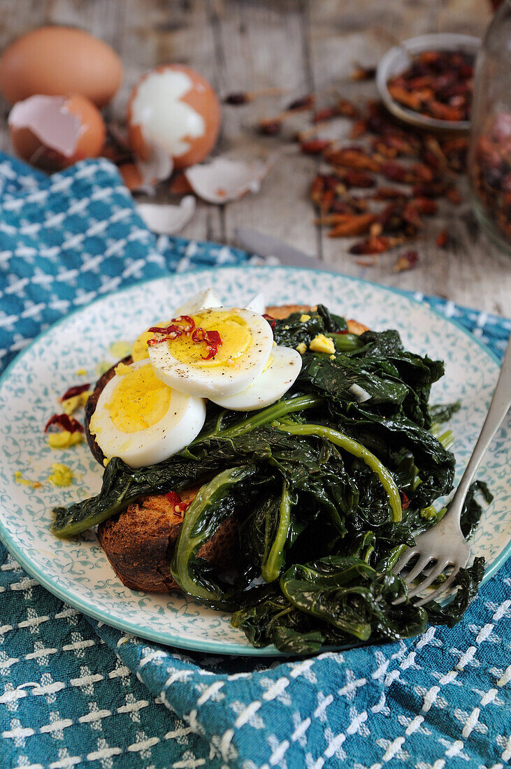 Sauteed kale with boiled eggs on bruschetta