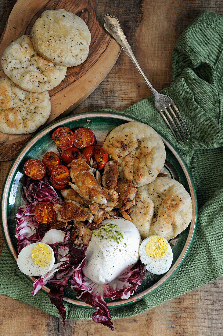 Salad with chicken, mozzarella, tomatoes, egg and pita bread