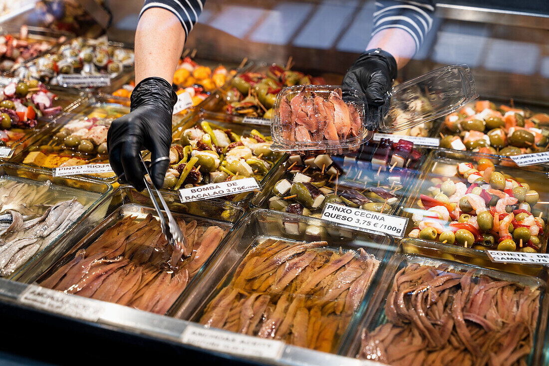 Market stall with anchovies and pickled vegetables in the market hall of Valencia, Spain