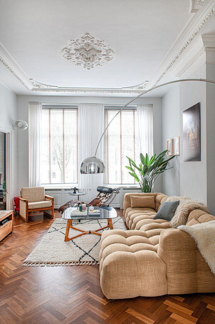 Old-style living room with comfortable sofa, arc lamp and stucco ceiling