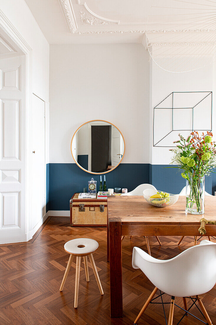 Wooden table with classic chairs in the old-style dining room with herringbone parquet flooring