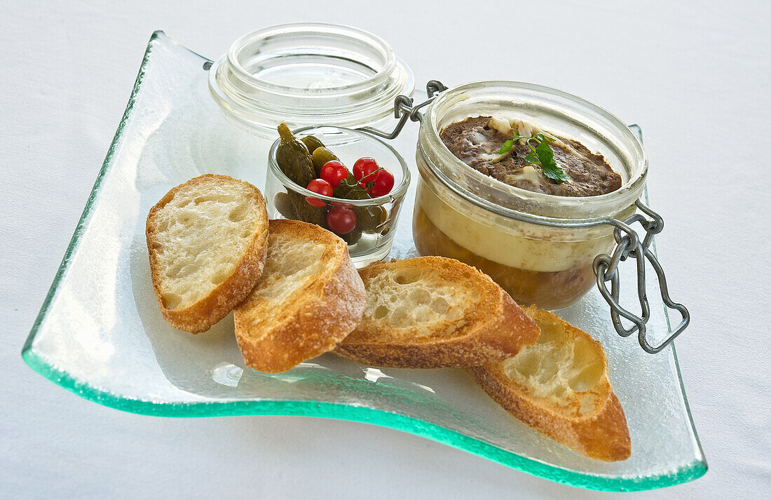 Boiled liver sausage, served with baguette, pickles, and tomatoes