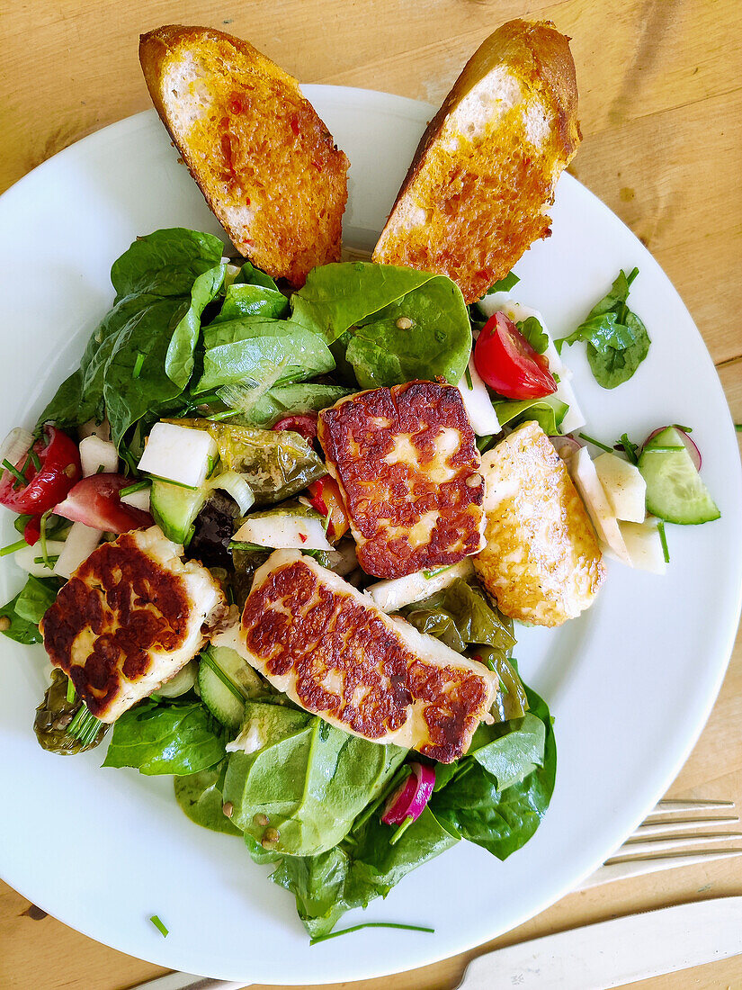 Baby spinach salad with kohlrabi, roasted pimientos and halloumi