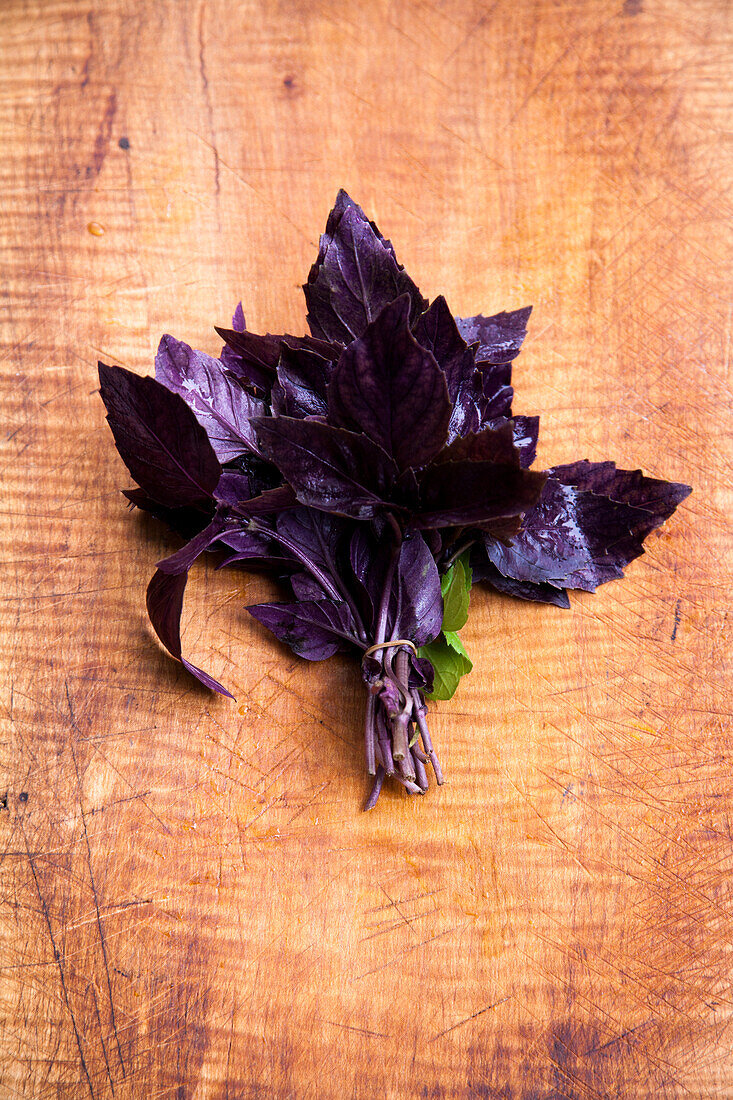 One bunch of red basil on a wooden background