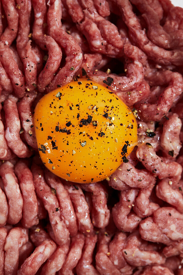 Raw ground meat with egg yolk, salt and pepper