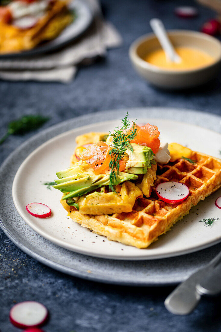 Potato waffles with avocado, salmon, dill, and radish