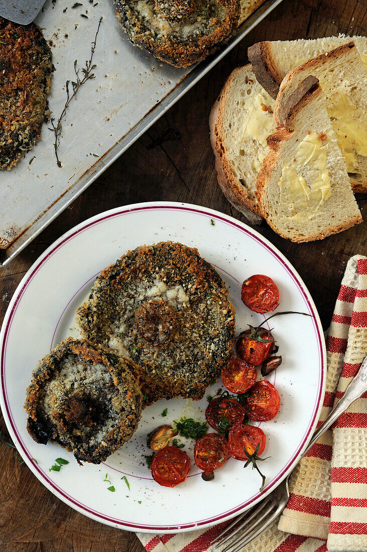 Breaded fried portobello mushrooms with roasted tomatoes